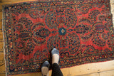 Vintage American Sarouk rug with diminutive central palmette, scrolling tendrils, floral bouquets on cherry red.