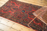 Vintage American Sarouk rug, featuring blue floral motifs and scrolling tendrils on a cherry red ground.