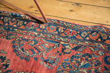American Sarouk rug corner, cherry red ground, navy blue floral vinery, slight curl.