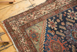 Hamadan runner corner: deep indigo Herati motifs, patterned borders, and worn fringe.