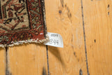 Close-up of a vintage Hamadan rug's geometric border and short, worn fringe.