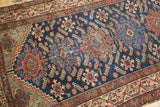 Hamadan runner's deep indigo field detail: geometric medallions, Herati leaves, sky blue, and rust hues.