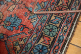 Vintage Lilihan rug's worn brick red, sky blue, green floral pattern and dark selvage.