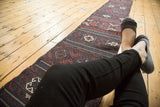 Antique Belouch Soumac runner in-situ, highlighting its long, narrow form and traditional patterns.