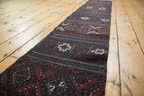 The narrow length and repeating traditional pattern of a late 19th-century Belouch Soumac runner.