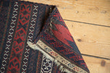 Folded corner of a Belouch Soumac showing the flatweave construction and traditional kilim end.