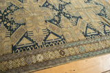 Antique Caucasian rug border with geometric wave and octagonal patterns in sand, navy, and light blue.
