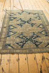 Lightly tattered end of an antique Caucasian rug with geometric navy and beige border.