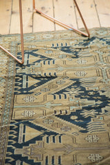 Intricate geometric motifs of an antique Caucasian rug's field, sand, navy, and pale blue.