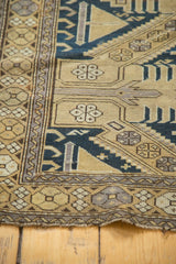 Antique Caucasian rug corner, geometric borders, sand field, dark navy patterns, light tatter.