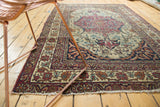 Antique Kermanshah rug corner with ornate Safavid borders, scrolling arabesques, and fringed end.