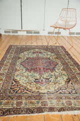 Antique Persian Kermanshah rug with Safavid-inspired arabesque borders and aged floral design.