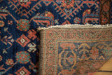 Reverse showing hand-knotted weave and fringe with rich indigo, terra cotta pile.