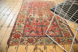 Antique Malayer rug corner, fringed, with beige border and red, sky blue floral motifs.