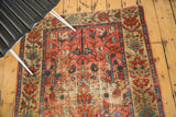 Antique Malayer rug corner with faded raspberry field, blue-green borders, and visible exposed foundation from wear.