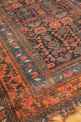 Antique Kurdish Bijar rug corner, featuring intricate floral borders and dense field patterns, showing natural edge tatter.