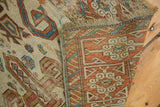 Geometric Kufic border in madder red and ivory with fringe on an antique hand-knotted Caucasian rug.