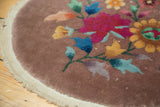 Collector Art Deco round rug edge showing secure plain weave and soft beige-mauve pile.
