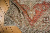 Distressed vintage Oushak rug: dusty red pile with visible worn knot heads and ivory floral motifs.