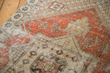Distressed vintage Oushak rug detail, worn dusty red and ivory geometric pattern with foundation showing.