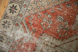 Distressed texture of vintage Oushak rug with faded dusty red and antique ivory floral pattern.