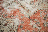 Textural close-up of distressed Oushak rug, highlighting worn dusty red and ivory tones.