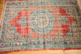Distressed pile texture on cherry red field, faded blue border, vintage Oushak rug.