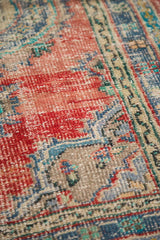 Distressed hand-knotted Oushak rug pile, featuring cherry red and faded blue.