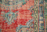 Distressed hand-knotted Oushak rug pile, revealing cherry red, mint green, blue patterns.