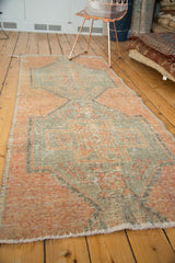 Distressed Oushak rug runner with blanket stitch overcast on worn apricot and silver pile.