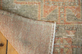 Distressed Oushak runner pile in apricot and silver with blanket-stitched edge and visible foundation.