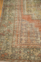 Distressed Oushak runner's corner spandrel, showing geometric patterns in faded terra cotta and beige.