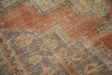 Vintage distressed Oushak rug texture, showing even wear in burnt orange and beige tones.