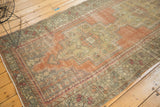 Detail of vintage distressed Oushak runner showing geometric patterns, terracotta and muted green tones.