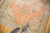 Distressed vintage Oushak rug, peach field, visible foundation, and scrolling mint green motifs.