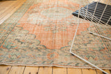 Distressed vintage Oushak rug showcasing faded peach, mint patterns, and visible foundation.