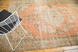 Distressed Turkish Oushak rug detail with peach field, faded floral motifs, and muted greens.