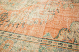 Distressed texture of vintage Oushak rug pile showing peach, mint, and ivory.