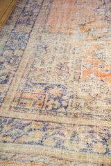Distressed vintage Oushak carpet texture showing worn knot heads, peach, blue, and ivory.