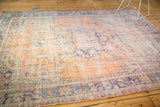 Distressed Oushak carpet with worn texture, faded peach, blue, and visible foundation.