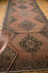 Distressed vintage Sparta runner detail with faded apricot field and dark blue-green motifs.
