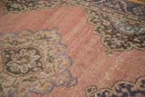 Distressed vintage Sparta runner with faded dusty apricot field and worn half-medallion details.