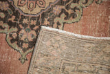 Distressed dusty apricot pile with dark patterns and its hand-knotted woven back.