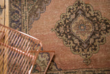Faded terra cotta field and dark brown, pistachio green medallion on a distressed Sparta runner.