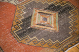 Distressed Oushak runner: geometric diamond motif in charcoal, dusty gold, and pale celadon green.