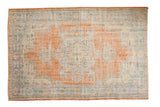 Hand-knotted Distressed Oushak carpet with dusty tangerine orange field and faded blue floral medallion.