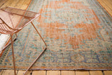 Distressed dusty tangerine orange and faded blue patterns on a vintage Oushak carpet.
