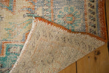 Vintage Distressed Oushak rug corner with worn pile, exposed ivory foundation, and orange secured edge.