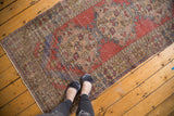 Vintage distressed Oushak runner with faded red, blue, ivory medallions and even wear.