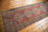 Distressed Oushak runner texture, showing faded red, antique ivory, and subtle pale blue.